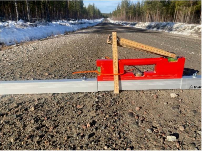 vattenpass och tumstock som visar lutning och sp&aring;rdjup